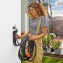 Frau schließt Gardena Liano Gartenschlauch-Set am Wasserhahn an. Flexibler Wasserschlauch mit Brause.