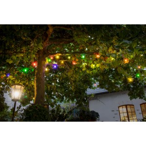 Konstsmide LED-Biergartenkette mit 20 bunten Lichtern, außen am Baum befestigt.