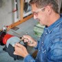 Einhell TC-WD 200/150 Nass-Trockenschleifer im Einsatz beim Schärfen einer Schere.