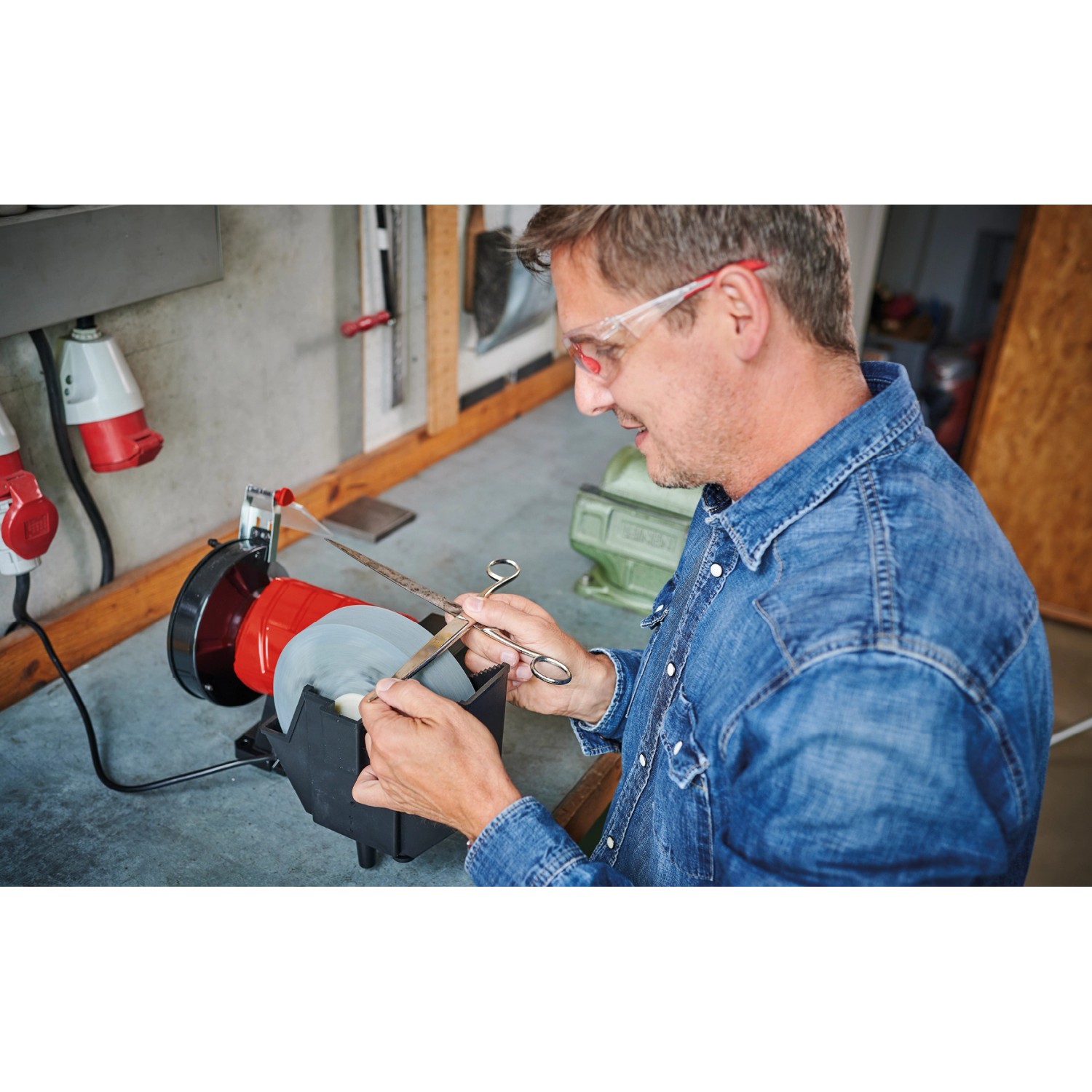 Einhell TC-WD 200/150 Nass-Trockenschleifer im Einsatz beim Schärfen einer Schere.