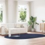 Ovaler marineblauer Shaggy Hochflorteppich aus Polyester im modernen Wohnzimmer auf Holzfußboden.