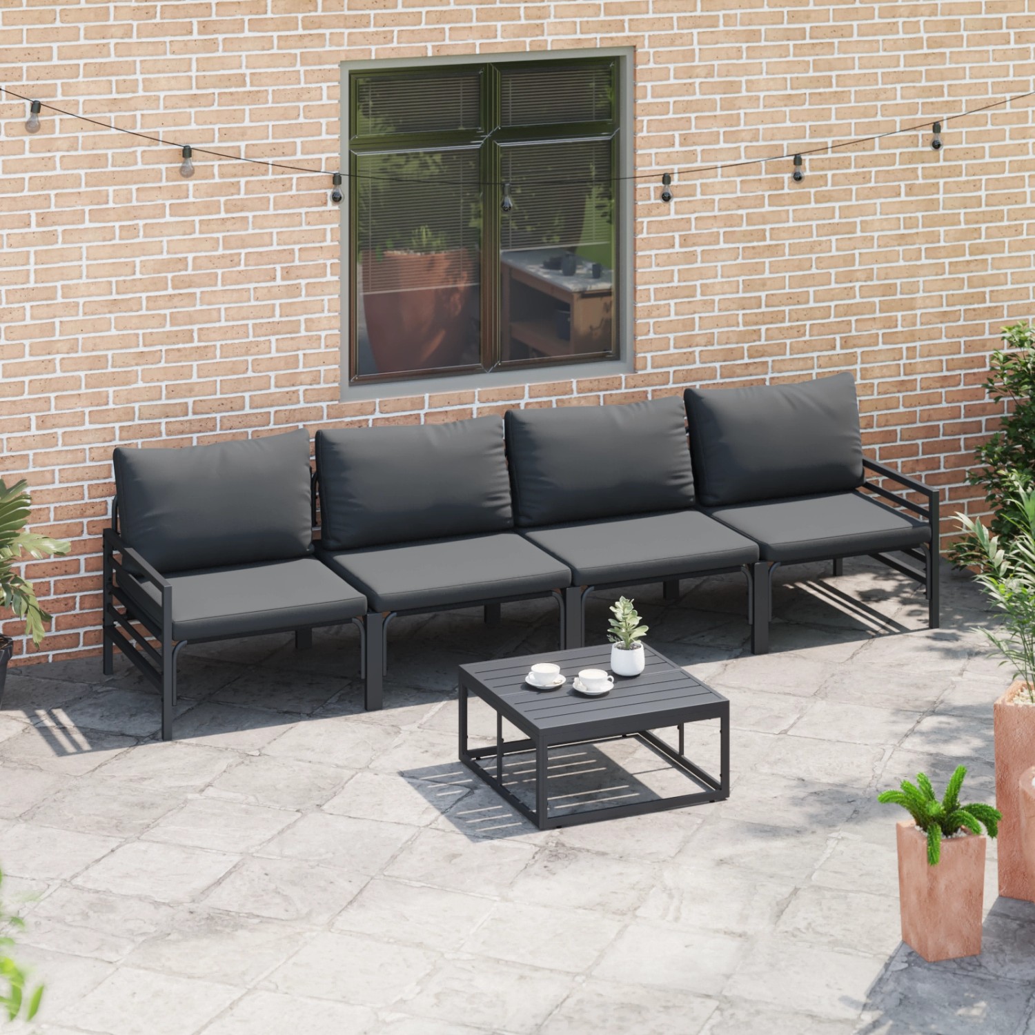Anthrazitfarbenes 4-teiliges Garten-Sofa-Set aus Stahl mit Tisch und bequemen Kissen.