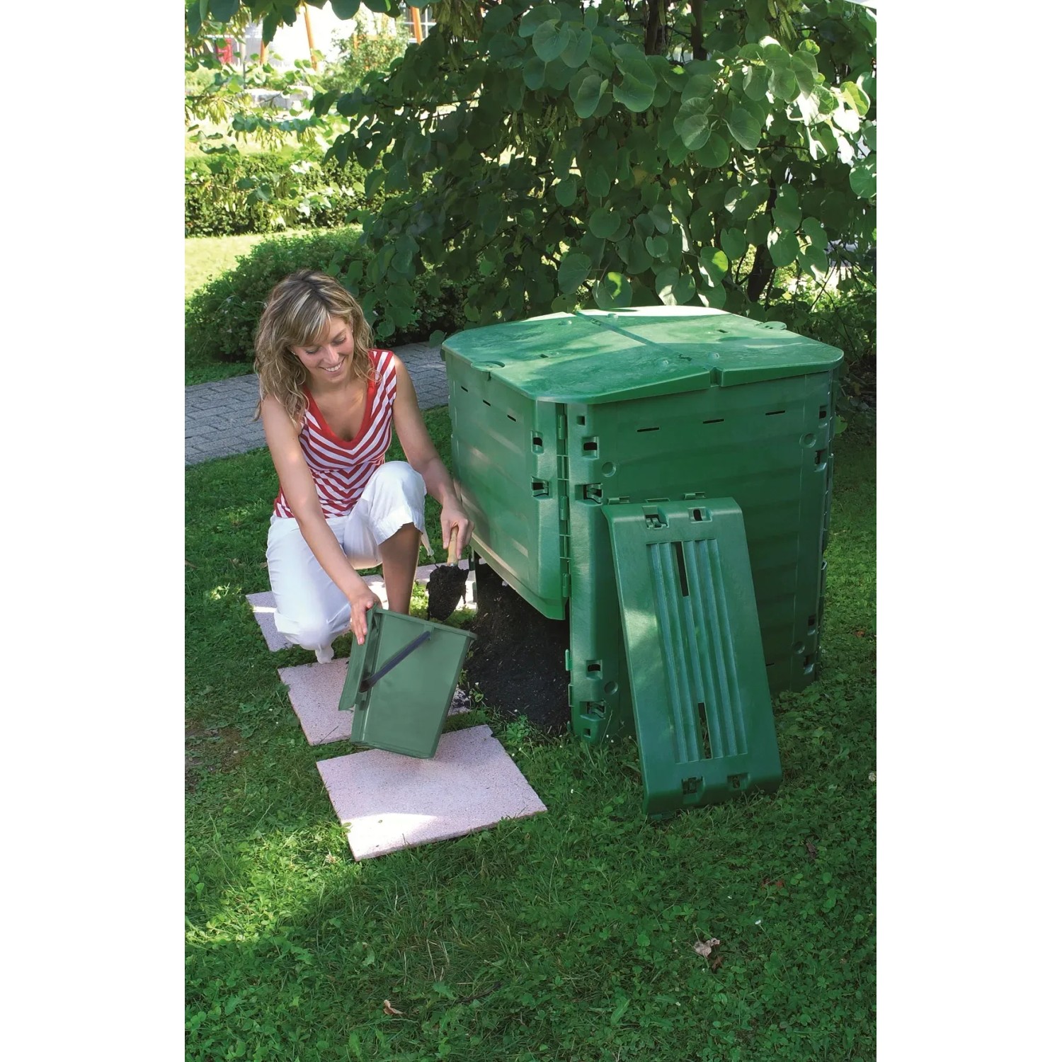 Garantia Thermo-King Komposter 600 l, grün, mit Frau bei der Befüllung im Garten.