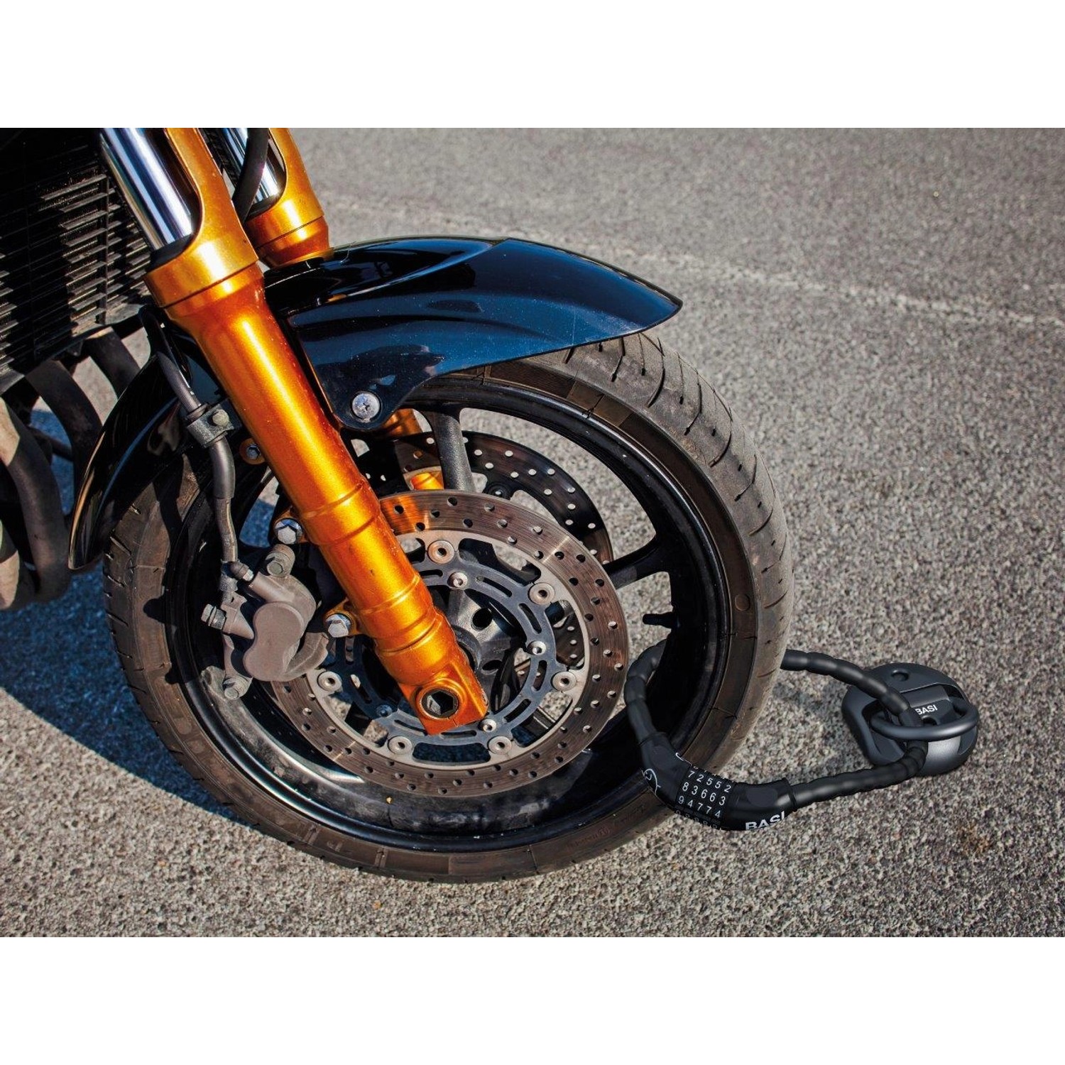 Motorrad mit Basi Boden-Wandanker BWA 110, ein schwarzes Fahrradschloss zur Diebstahlsicherung.