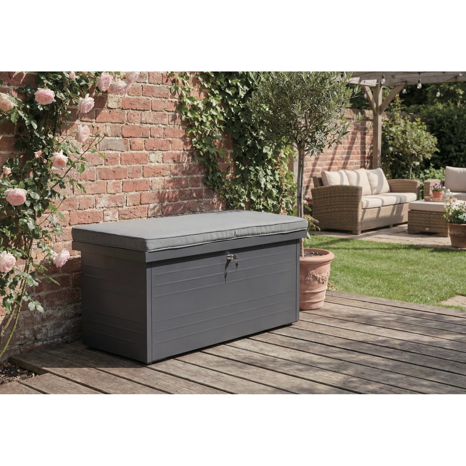 Anthrazitfarbene Stahl-Aufbewahrungsbox mit grauem Sitzkissen auf Holzterrasse. Ideal als Gartenbox & Bank.