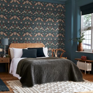 Schlafzimmer mit William Morris Vliestapete Strawberry Thief Deep Blau mit Vogel- und Erdbeermuster.