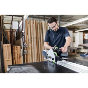 Mann sägt mit Festool Akku-Tauchsäge TSC55KEB-Basic 18V, 160mm Sägeblatt, präzise auf Führungsschiene.