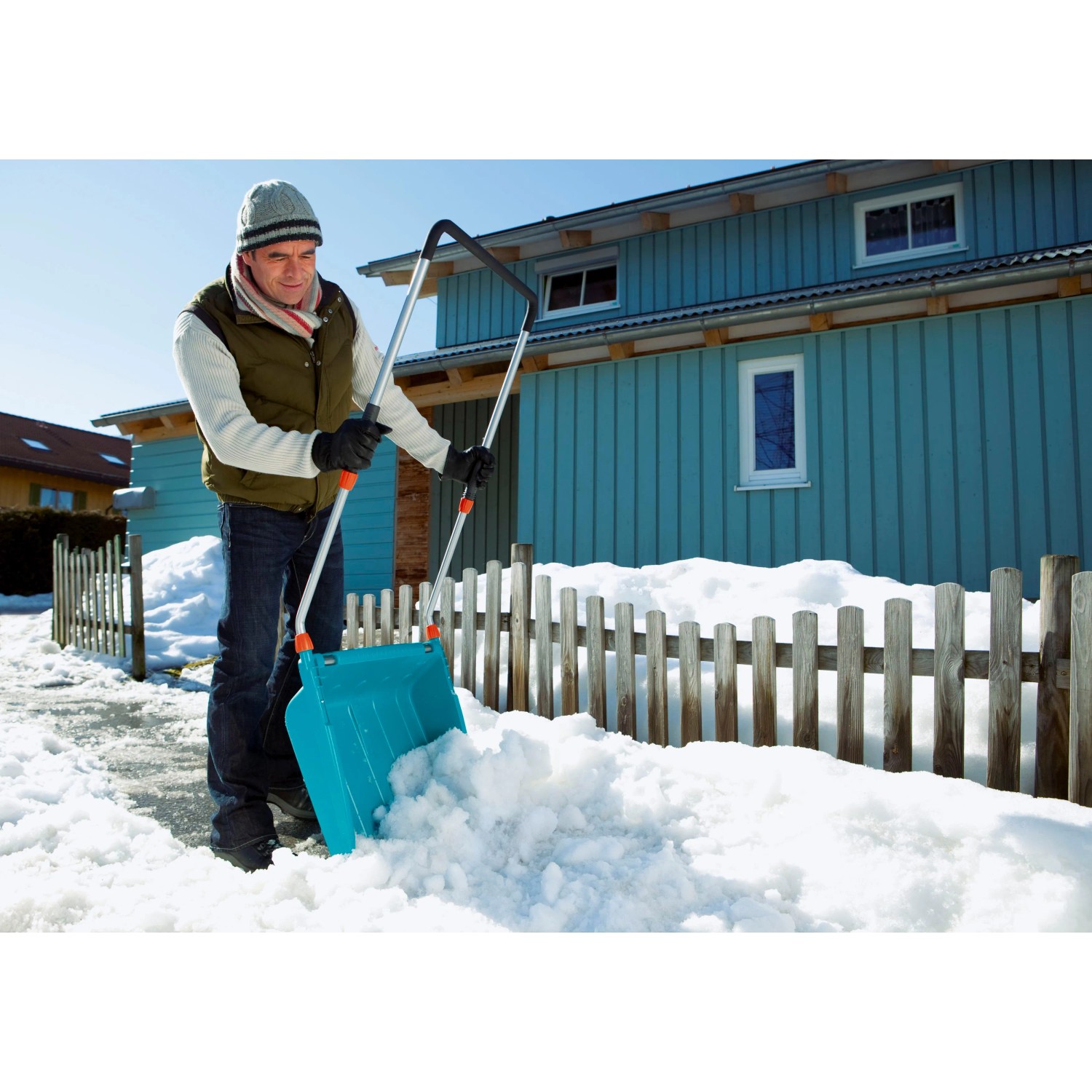 Mann schiebt Schnee mit der Gardena Schneewanne 70 cm. Ideal für größere Flächen.