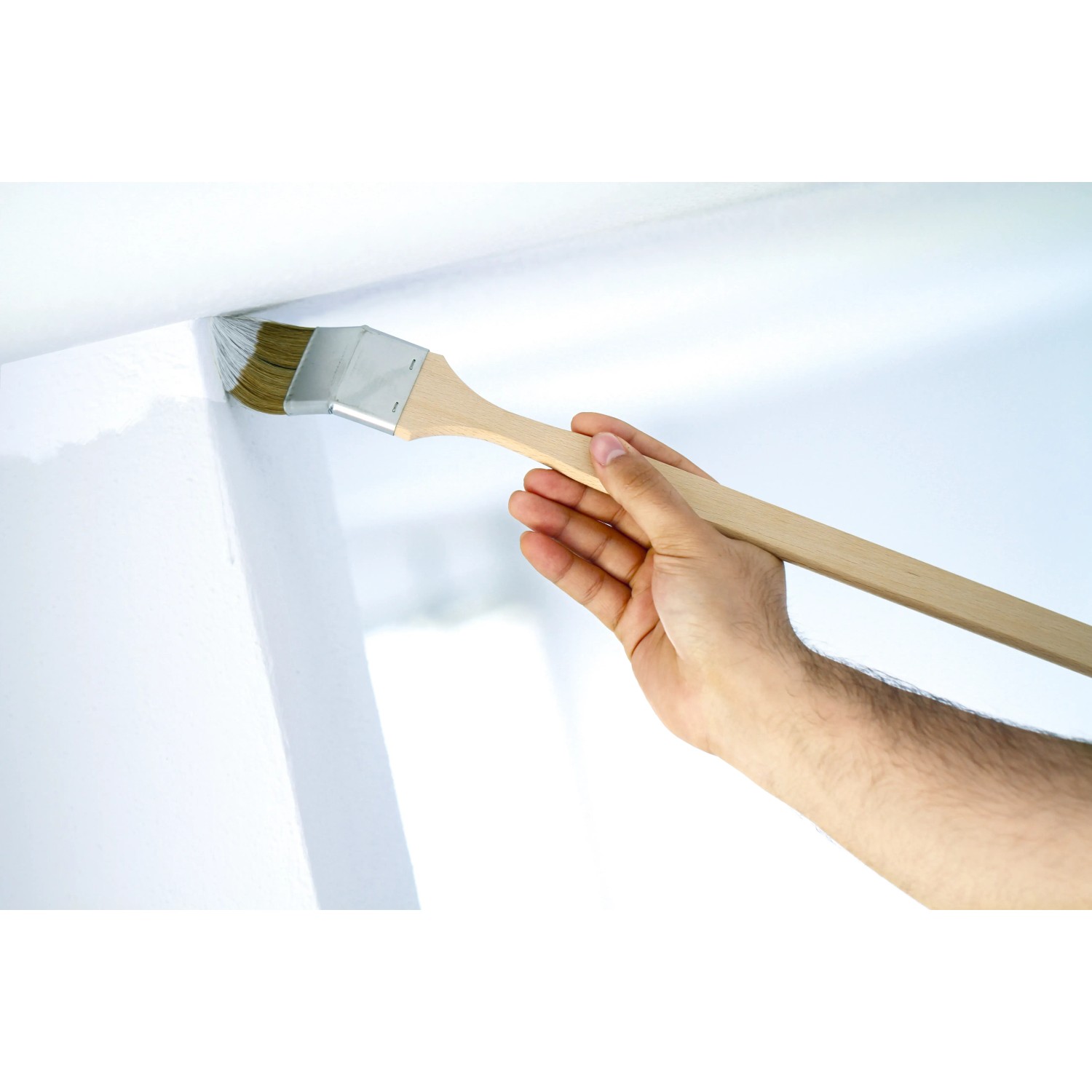 LUX Eckenpinsel 35mm im Einsatz: Hand streicht Ecke mit Dispersionsfarbe. Ideal für schwer zugängliche Stellen.