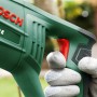 Bosch PSA 900 E Säbelsäge in Grün mit Hand am Griff. Ideal für Sägearbeiten.