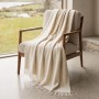 Elfenbeinfarbene Sofadecke aus Baumwoll-Mix auf Sessel. Leichte Wohndecke 130x170 cm für Sofa & Bett.
