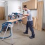Mann nutzt Bosch Professional Kapp- und Gehrungssäge GCM 340-305 D zum präzisen Schneiden von Holz auf einer Werkbank.