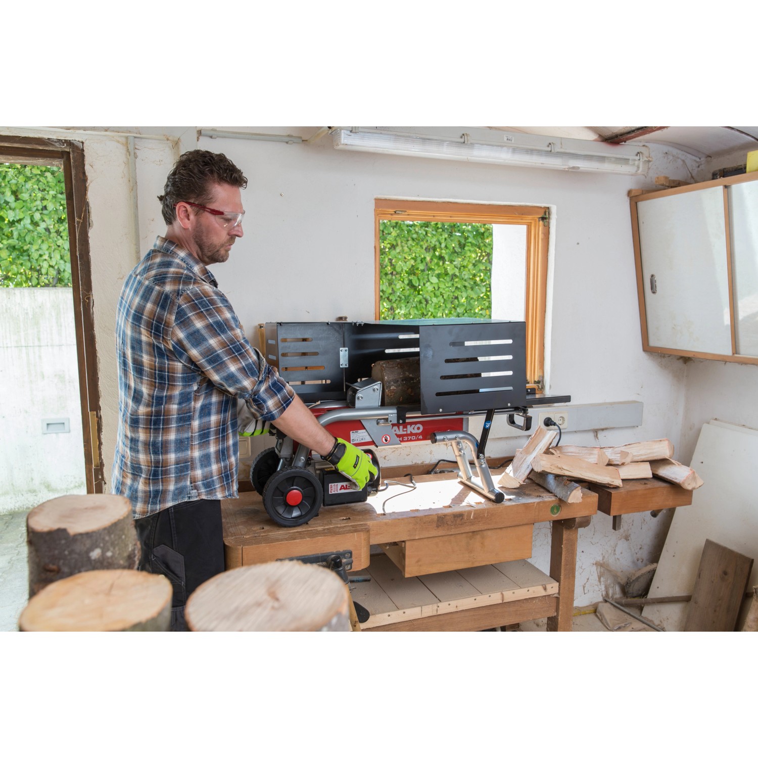 Al-Ko Elektroholzspalter LSH 370/4 in Nutzung: Holzspalter mit Mann beim Holz spalten.
