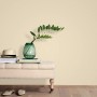 Beige Vliestapete „Paradisio 2 Uni“ von Erismann an Wand, kombiniert mit Deko-Elementen.