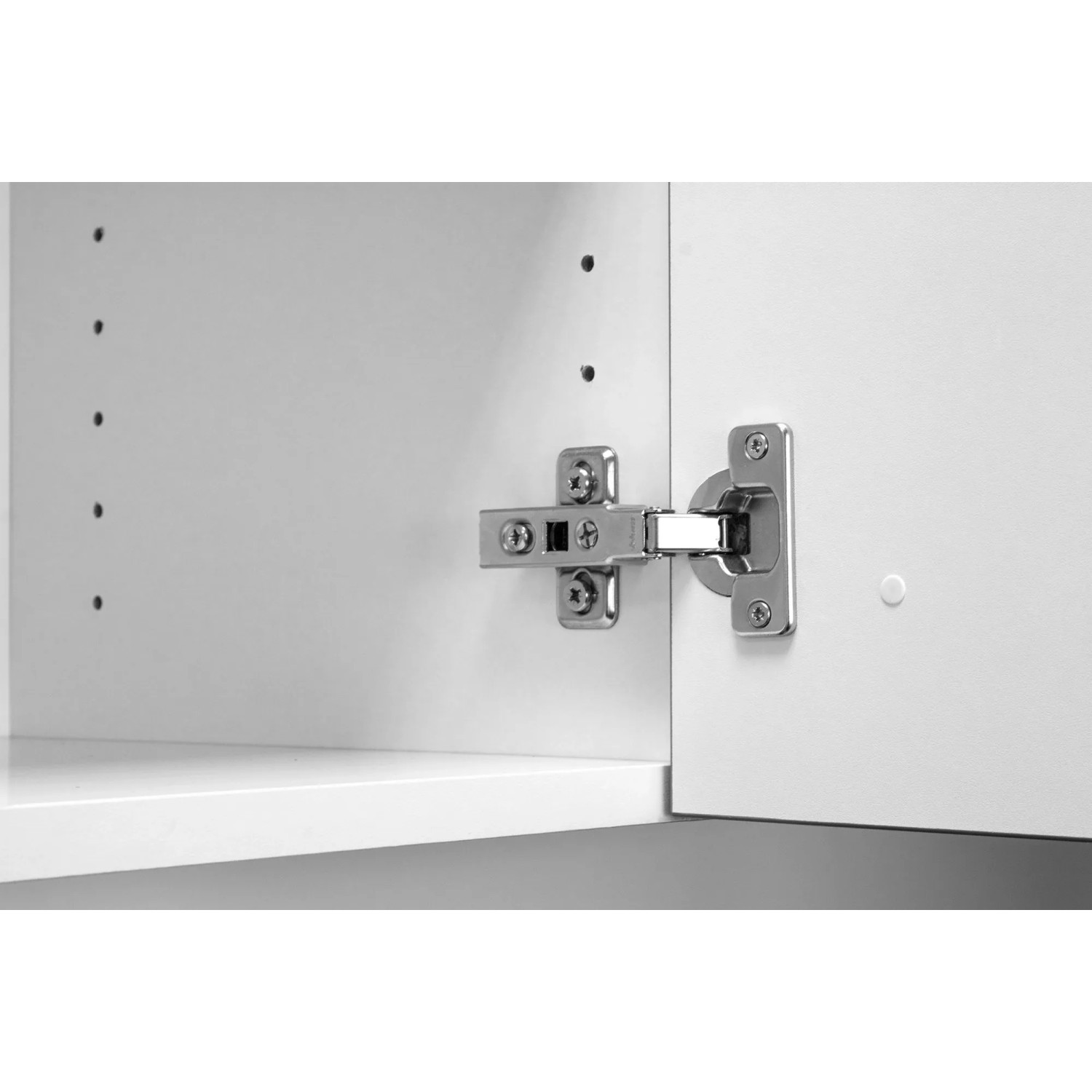 Detailaufnahme eines Scharniers an einer weißen OPTIFIT Miniküche. Fokus auf die hochwertige Verarbeitung.