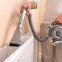 Frau saugt mit Black+Decker Akku-Handstaubsauger Dustbuster Flexi PD1820L einen Heizkörper ab.
