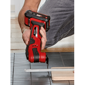 Einhell Multitool mit montiertem Sägeblatt im Einsatz beim Sägen eines Werkstücks.