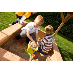 Kinder spielen im Sandkasten des Axi Sarah Spielhauses (braun/grün) mit Sandspielzeug.