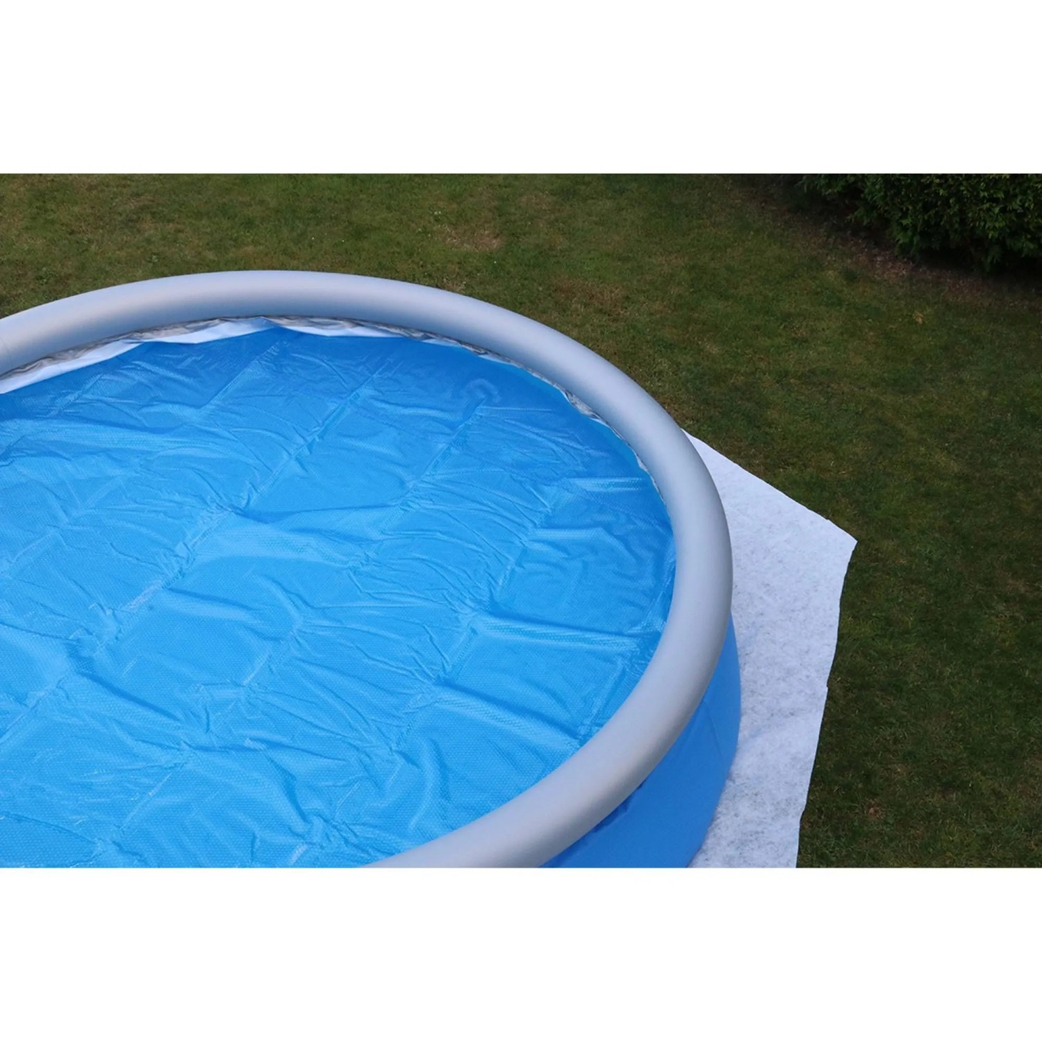 Planet Pool Bodenschutzvlies unter einem Pool mit blauem Innenleben auf Rasen.