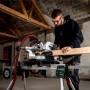 Metabo Kappsäge KGS 216 M Set beim Zuschnitt von Holz auf einem Sägetisch.