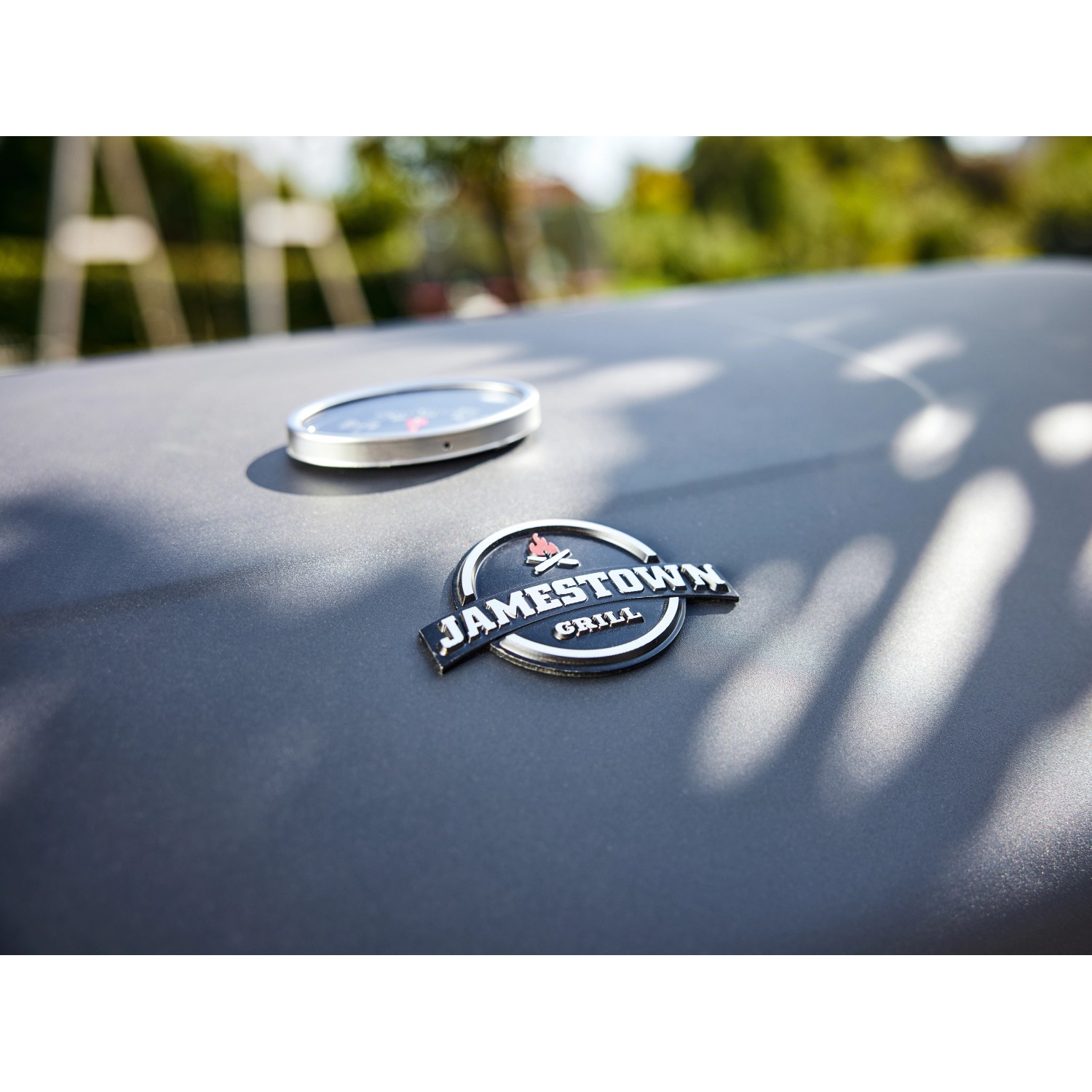 Detailansicht: Jamestown Holzkohlegrill Jaxon mit Thermometer und Logo.