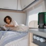 Grüner Bosch Akku-Bluetooth-Lautsprecher UniversalSpeaker 18V-1 auf Tisch in Wohnmobil. Kompaktes Akkugerät für kabelloses Streaming.