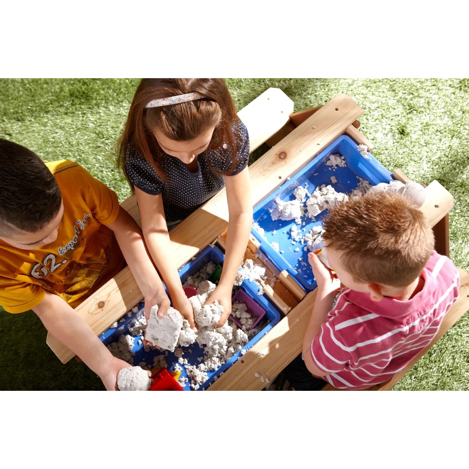 Kinder spielen am Sand- und Wasserspieltisch Nick Braun im Garten.