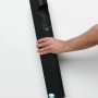 Anthrazitfarbener Wandascher aus Stahl mit Abstreifblech, von Hand gehalten vor weißer Wand. 3,5 Liter Mülleimer.