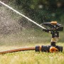 Fiskars Impulsregner mit Erdspieß bewässert Rasenfläche. Sprinkler-System für Garten.