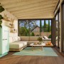 Innenansicht: Palmako Holz-Gartenhaus mit Pultdach, weiß lackiert, eingerichtet mit Möbeln.