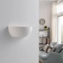 Moderne weiße Gips-Wandleuchte Jimmy an weißer Wand im Wohnzimmer. Schalenform, Licht oben und unten.