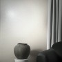 Weiße Marburg Vliestapete Uni Metalloptik im Wohnraum mit Vase und Sofa.