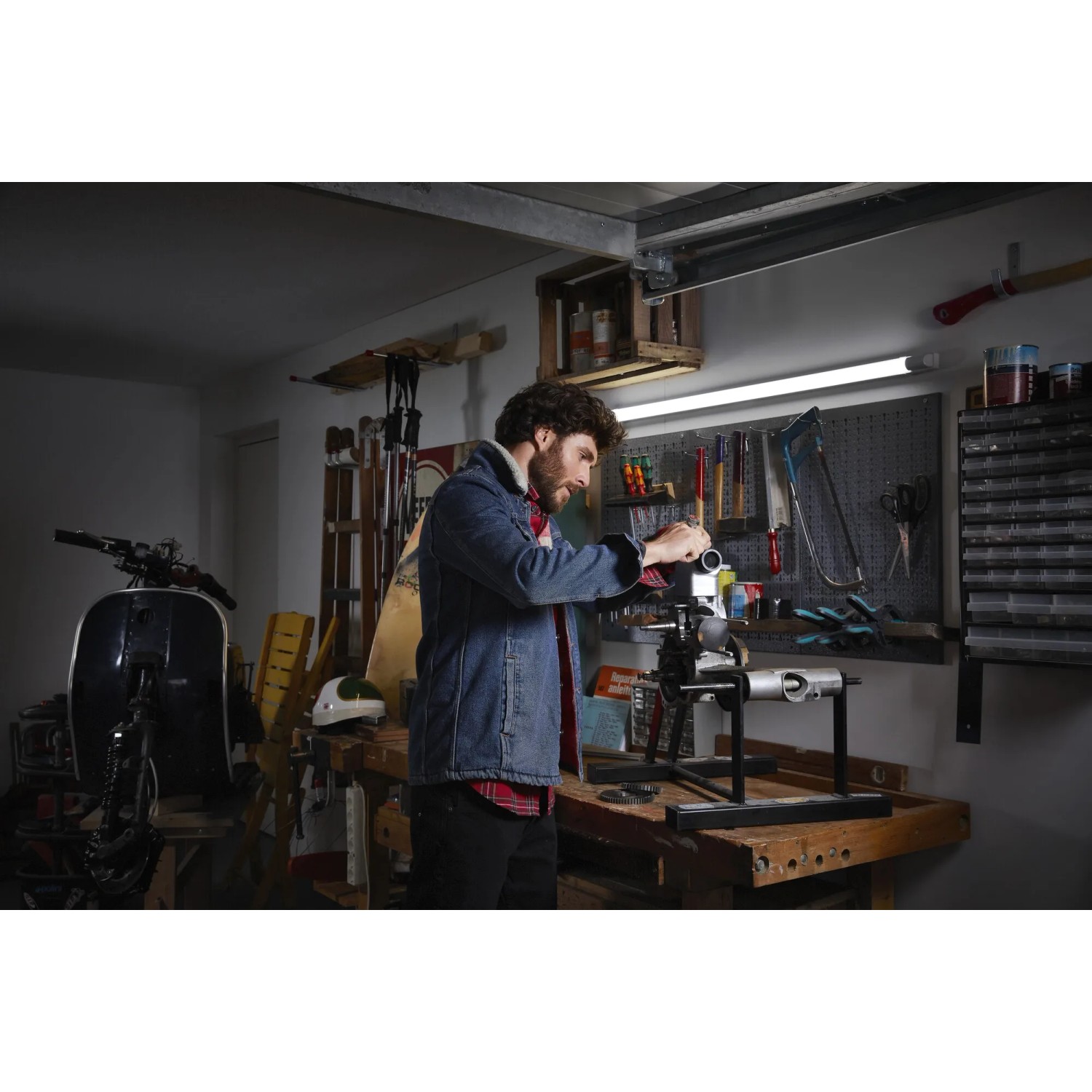 Mann arbeitet unter Ledvance LED-Lichtleiste Power Batten 120 cm in Werkstatt.