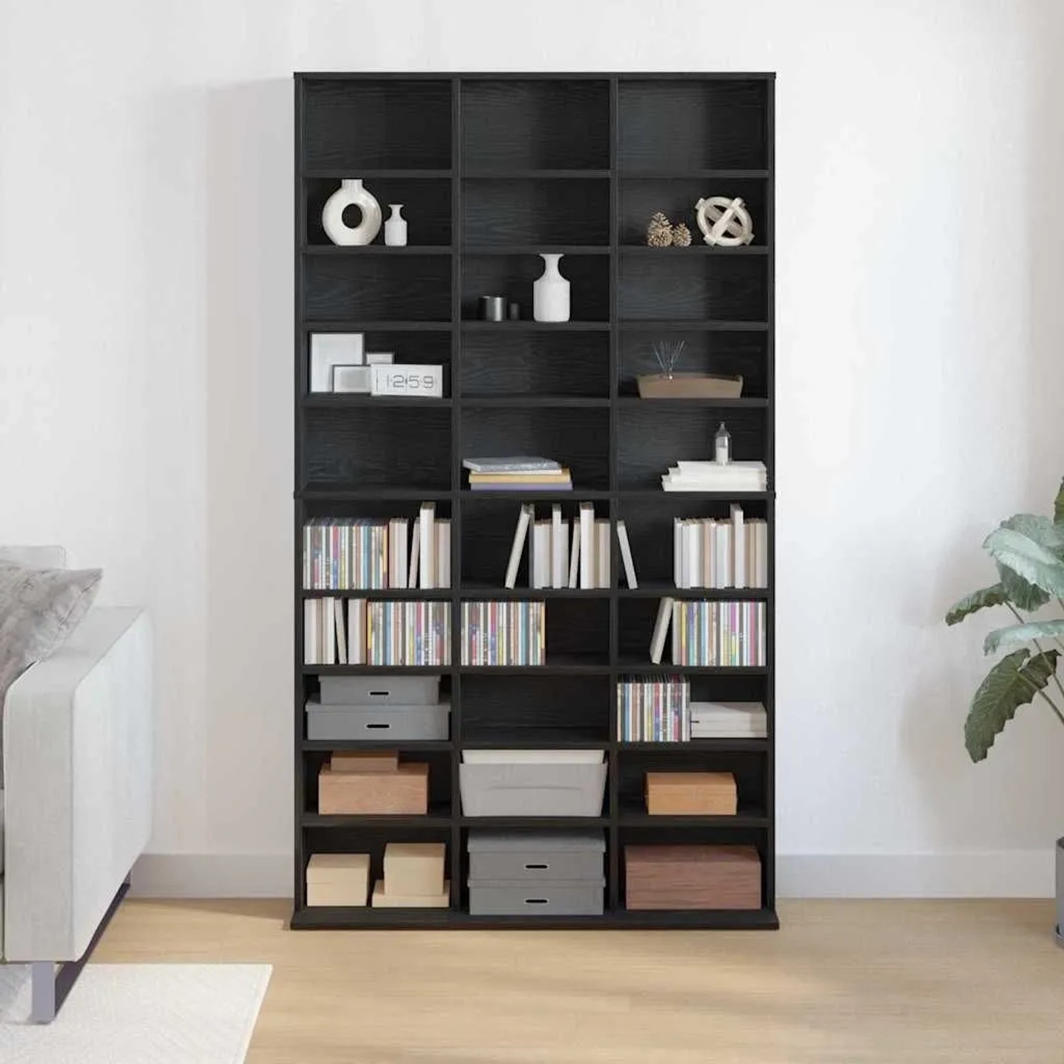 Hohes, schwarzes CD Regal in Eichen-Optik mit vielen Fächern für CDs, DVDs und Deko im Wohnzimmer.