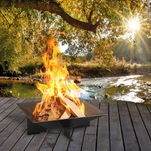 Quadratische Wilk Feuerschale 56x56x20 cm mit brennendem Holz vor Flusslandschaft.