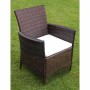 Brauner vidaXL Gartenstuhl aus Rattan mit cremeweißem Sitzkissen auf Rasen.