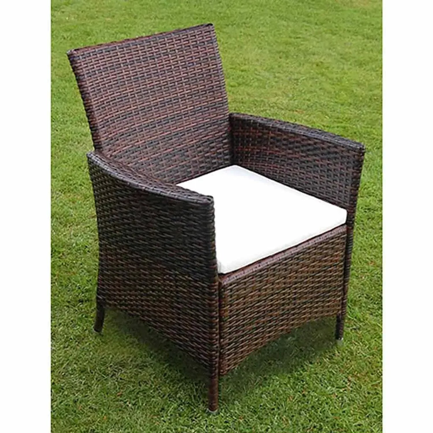 Brauner vidaXL Gartenstuhl aus Rattan mit cremeweißem Sitzkissen auf Rasen.