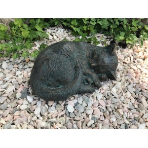 Schlafende Rottenecker Bronze-Katze als Gartendeko auf Kies.