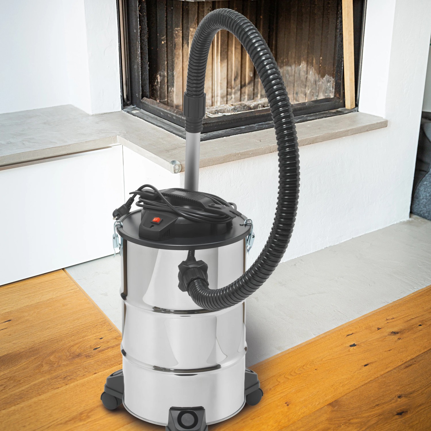 Aschesauger AS-20/1200 A aus Edelstahl vor Kamin, mit Schlauch und Rollen.
