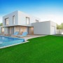 Satter, grüner Karat Kunstrasen Vita mit 40 mm Höhe vor modernem Haus mit Pool.
