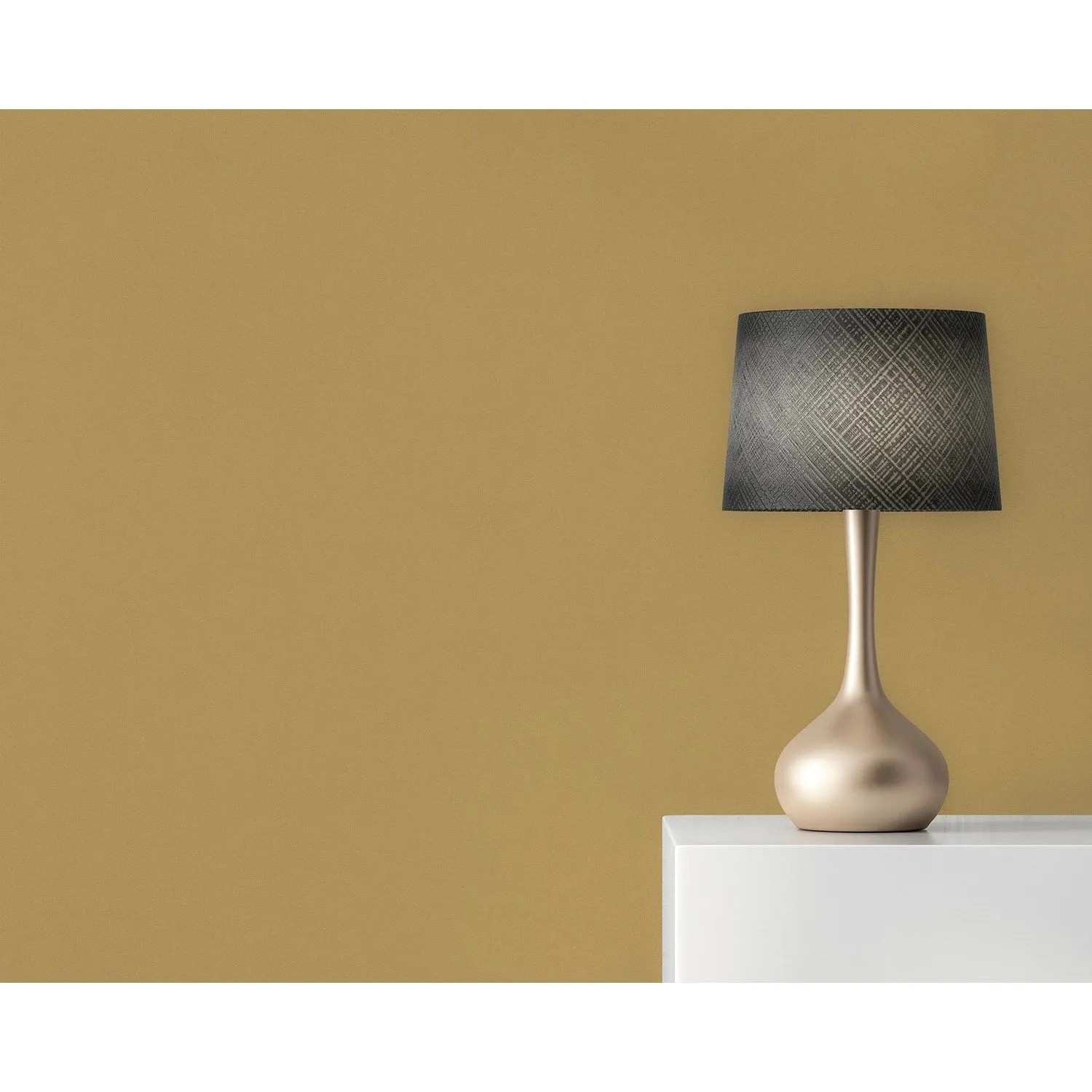 Tadessi Vliestapete Uni in Gelb an einer Wand, mit moderner Lampe auf weißem Tisch. Dekorative Tapete.
