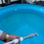Pool-Handsauger im Einsatz: Akku-Poolsauger mit Teleskopstange reinigt Pool.