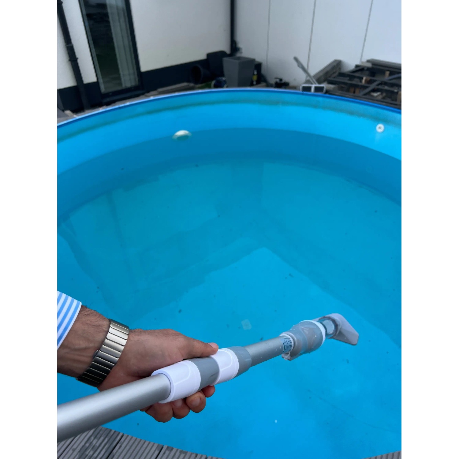 Pool-Handsauger im Einsatz: Akku-Poolsauger mit Teleskopstange reinigt Pool.