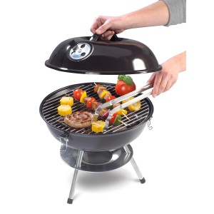 Schwarzer Holzkohle-Kugelgrill Mini mit Grillgut und Grillzange. Kompakter Grill für unterwegs.