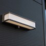 Moderne, anthrazitfarbene Lutec Solar-LED-Wandleuchte Doblo, 35 cm breit, mit integriertem Solarpanel.