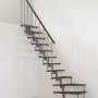 Minka Raumspartreppe Style Turn, Walnuss/Grau, mit Holzstufen und grauem Geländer.