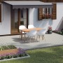 Verlegte, weiß gewaschene Rechteck-Pflastersteine aus Beton (20x10x6 cm) auf einer Terrasse mit Gartenmöbeln.