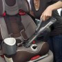 Black+Decker Akku-Handstaubsauger DVA320J im Einsatz zur Reinigung eines Kindersitzes.