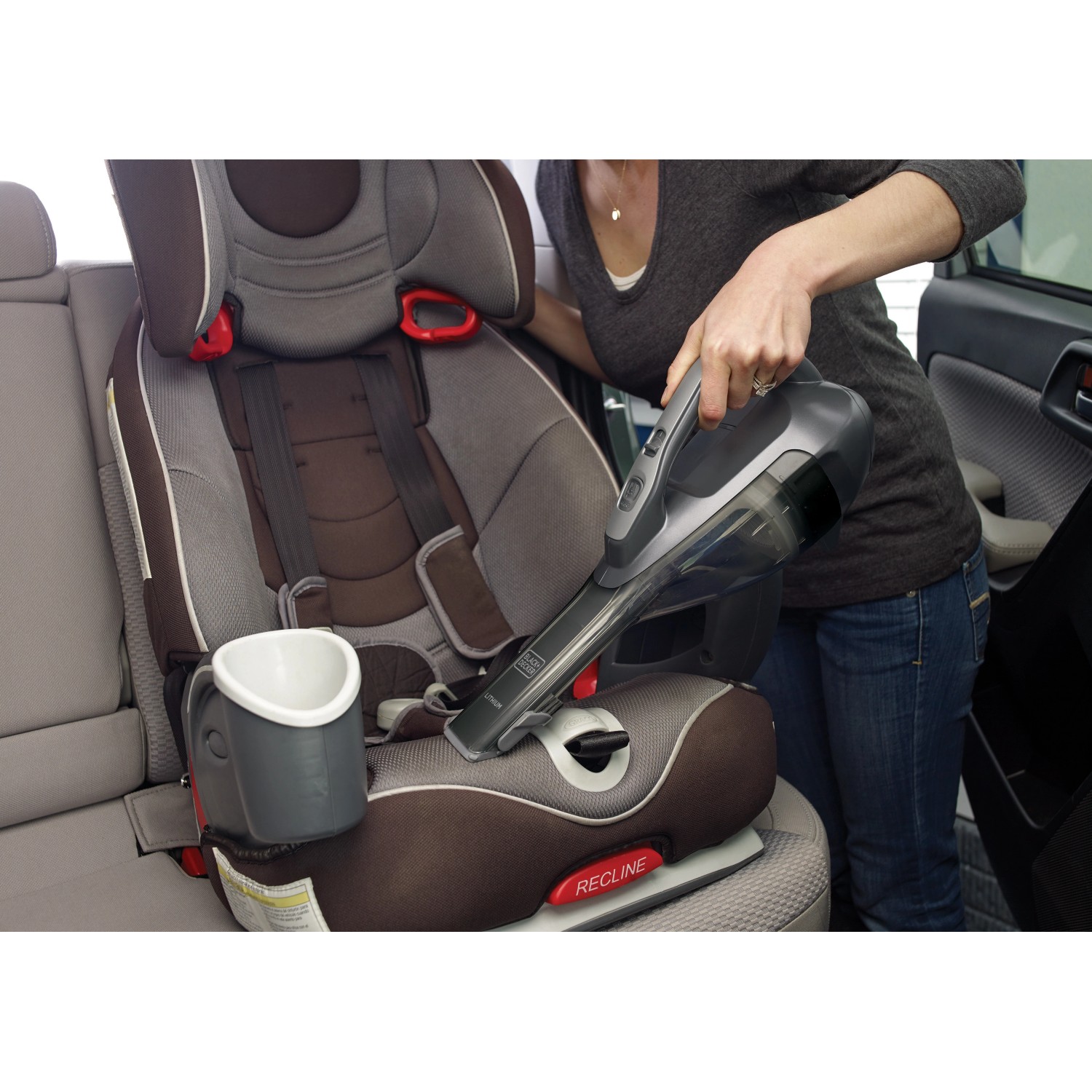 Black+Decker Akku-Handstaubsauger DVA320J im Einsatz zur Reinigung eines Kindersitzes.