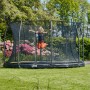 Schwarzes Salta Comfort Edition Bodentrampolin ø 366 cm mit Sicherheitsnetz, Kind springt im Garten.